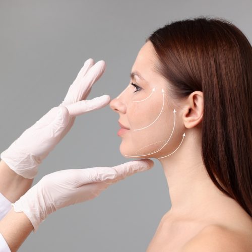 Woman,Preparing,For,Plastic,Surgery,,Grey,Background.,Doctor,Examining,Her